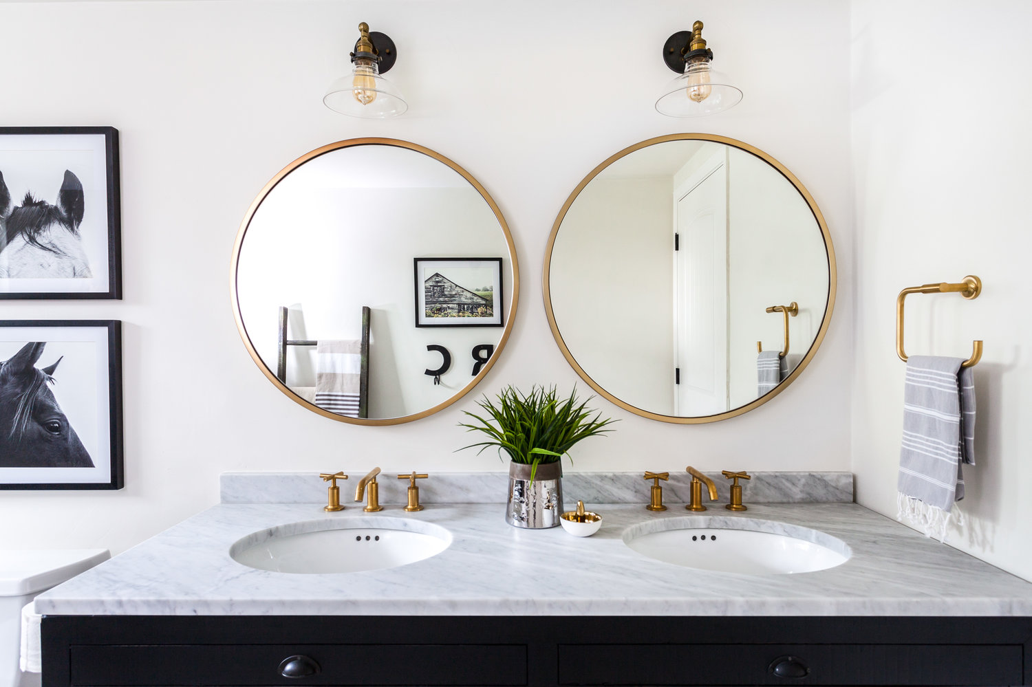 round mirrors and art in bathroom