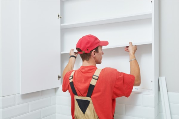 handyman replacing cabinet shelving