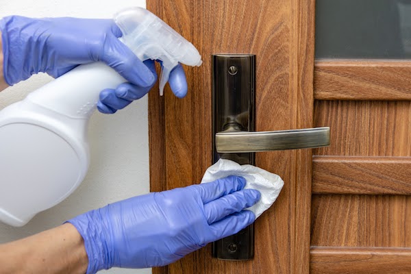 person spring cleaning door knob handles