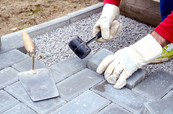 worker laying patio stone