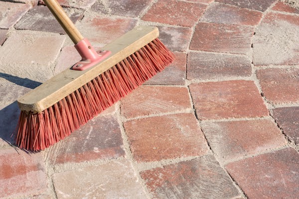brushing sand into joint of pavers