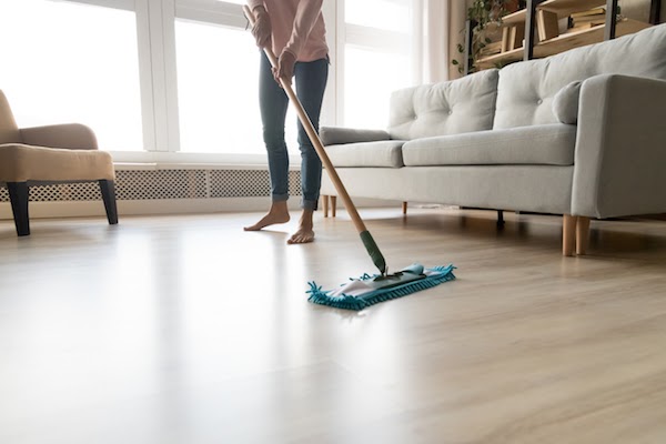person dry mopping laminate floor
