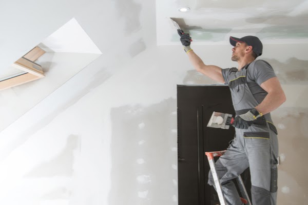 pro applying spackle to ceiling