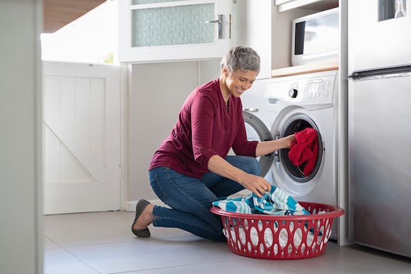 woman putting laundry into washing machine