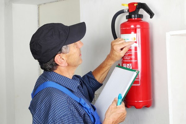 man checking expiry on fire extinguisher