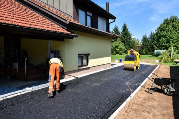 laying new asphalt driveway in summer