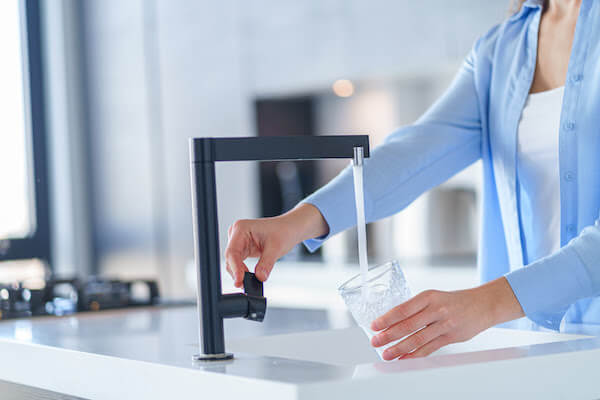 woman getting a glass of tap water