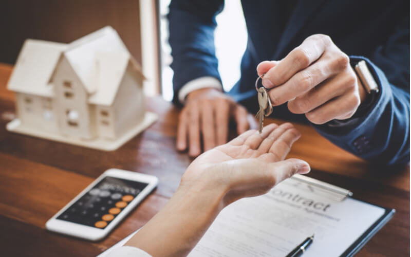 Real estate agent Sales manager holding filing keys to customer after signing rental lease contract of sale purchase agreement, concerning mortgage loan offer for and house insurance.