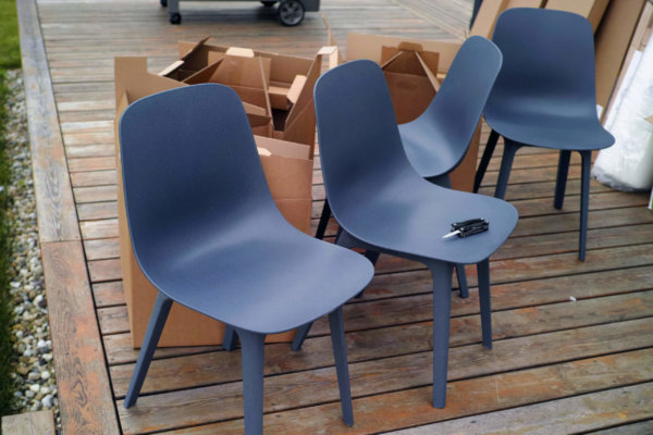 New plastic chairs assembling, a bunch of used cardboard boxes in the background, outdoor image