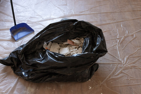 Construction garbage after apartment repair in a black plastic bag. Cleaning after renovation work. close-up.
