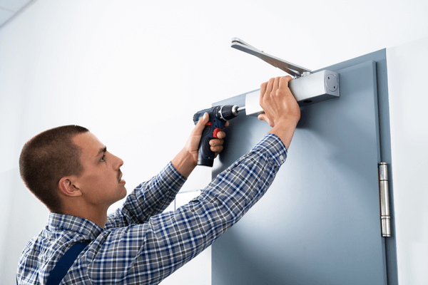 Handyman Installing And Fixing Automatic Door Closer. Maintenance And Service
