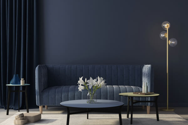 Modern interior of the living room in monochrome blue with a stylish velvet sofa, a beige carpet, a golden floor lamp / 3D illustration, 3d render
