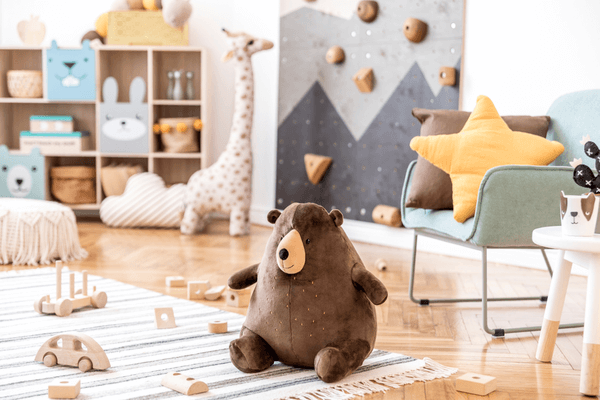 Modern scandinavian interior design of childroom with mint armchair, climbing wall for kids, design furnitures, soft toys, teddy bear and cute children's accessories. Stylish kidroom decor.