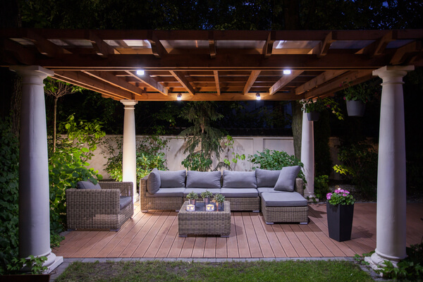 pergola in backyard with seating and lights