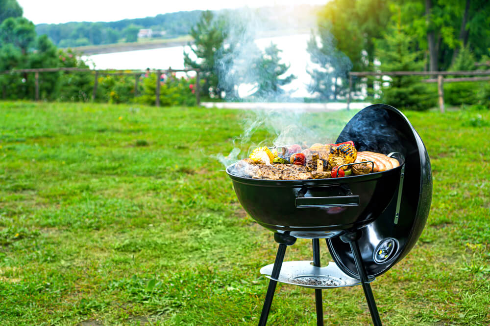 Barbecue time at the nature. BBQ grilling on the shore of a picturesque lake. Copy space.