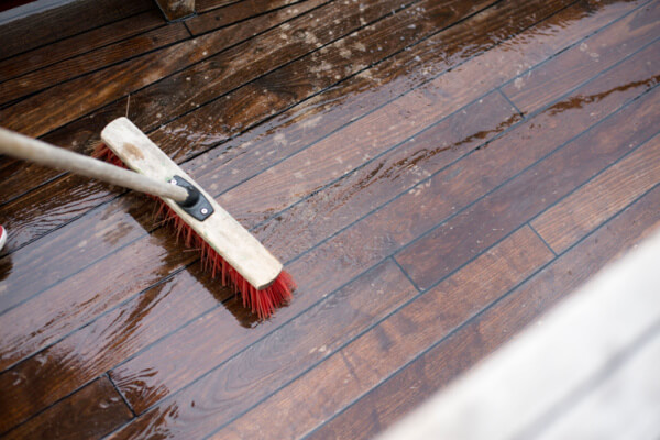 scrubbing wooden deck with soap and water