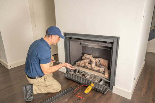 pro inspecting gas fireplace